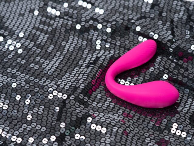 a pink object sitting on top of a black sequin bag