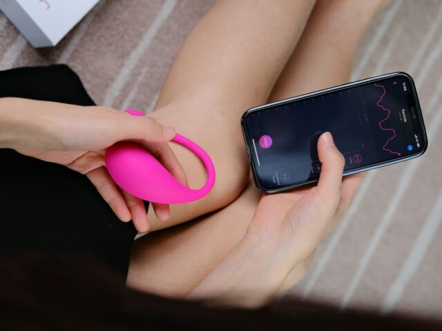 a woman holding a cell phone and a pink object